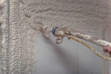 A worker plastered the interior walls with a plaster pump machine on the construction of a private...