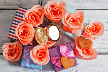 Opened blank locket surrounded by roses and gifts