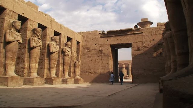 People walk through ancient statues in Egypt