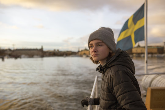 Boy on a boat with the Swedish flag in Stockholm, Sweden