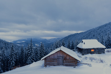 Fantastic winter landscape with wooden house in snowy mountains. Christmas holiday concept. Carpathians mountain, Ukraine, Europe