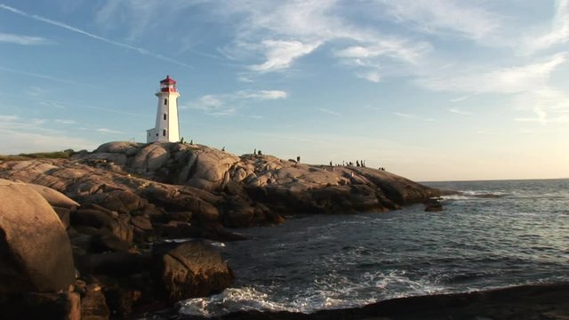 Low angle, people around scenic Nova Scotia lighthouse