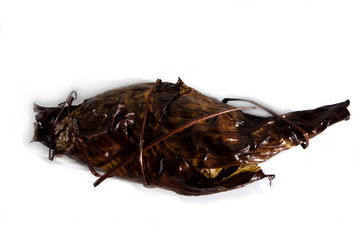 Fototapeta premium Grill fish gilt-head bream wrapped in banana leaf isolated on white background. Sparus aurata.