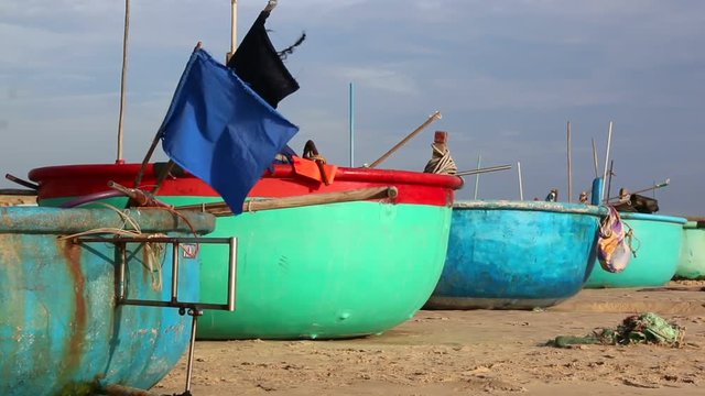 Traditional Vietnamese fishing coracles on beach, boats at fishing village