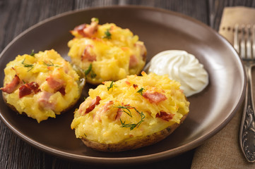 Ham and cheese jacket potatoes on dark background.