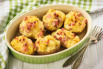 Ham and cheese jacket potatoes on dark background.