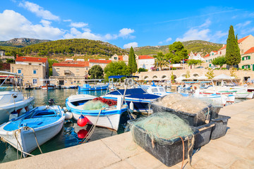 Fototapeta na wymiar Baskets with fishing nets and colorful boats in Bol port, Brac island, Croatia