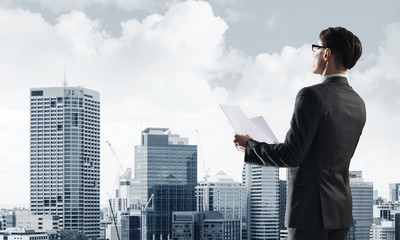 Concept of business success and control with confident boss against cityscape background