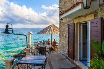 BOL PORT, BRAC ISLAND - SEP 8, 2017: Fishing restaurant tables and couple of people having drinks...