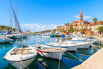Fototapeta na wymiar Fishing boats and view of beautiful church in Milna port on sunny summer day, Brac island, Croatia