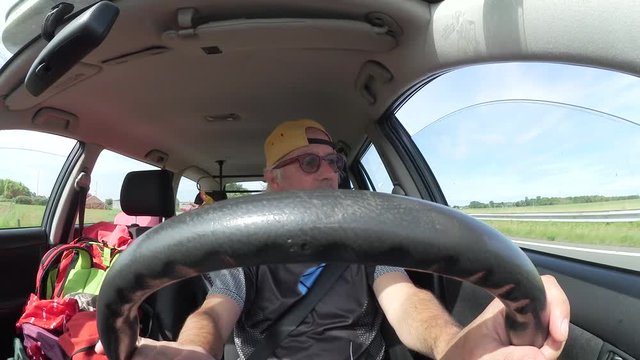 Uomo guida la automobile in vacanza con lo zaino