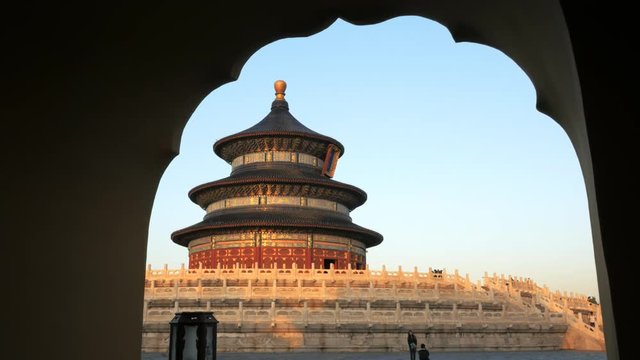 sunset view of the temple of heaven in beijing, china framed by an arch