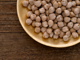Chickpeas on gold colour plate, closeup.