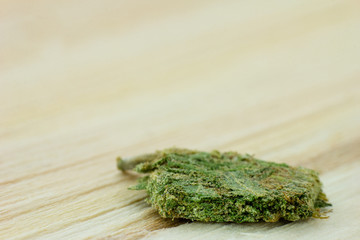 Medical Cannabis - pressed medical marijuana flower on the oak wood background.