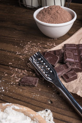 Dark chocolate and cocoa powder on rustic background and space for text