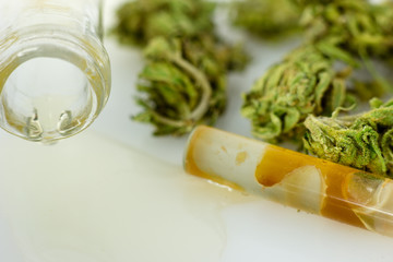 Medical Oil Cannabis - apothecary bootle with oil and marijuana flowers on the white background.