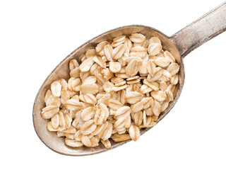 Coarsely rolled organic wholegrain oats on spoon, isolated on white.