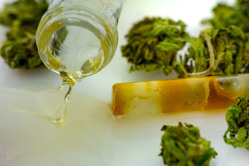 Medical Oil Cannabis - apothecary bootle with oil and marijuana flowers on the white background.