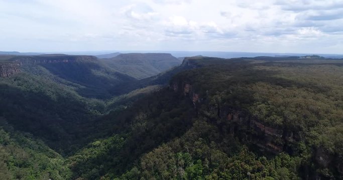 Rotation over Morton national park along Yarrunga creek off Fitzroy falls, gum-tree woods and sandstone cliffs of the mountains in wide panoramic view.
