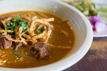 Egg Noodle in beef with curry and crispy noodle on top (Kao Soi), Traditional Chiangmai thai cuisine made of fresh ingredients.
