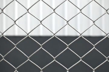 Fototapeta premium A metal fence against a white and gray background