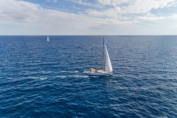 Aerial view on a white yacht under a white sail. Montenegro.