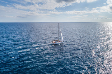 Naklejka premium Aerial view on a white yacht under a white sail. Montenegro.
