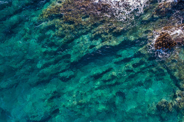 Aerial view of the green waves that beat the sea cliffs