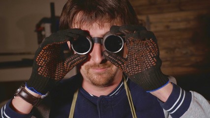 Portrait of industrial welder dresses protective glasses.
