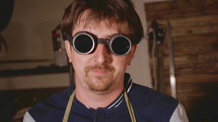 Portrait of industrial welder in protective glasses looking at camera.