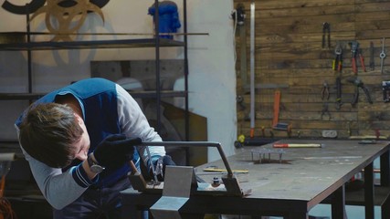 Blacksmith working with metal decorative detail at his workshop