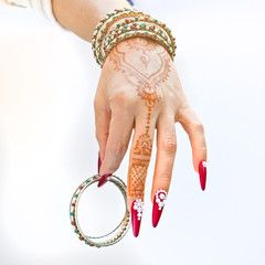 nails decorated with brilliant and hand with henna tattoos