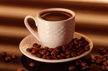 Hot Coffee cup with Coffee beans on the black table