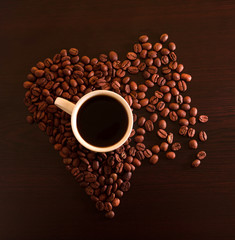 Hot Coffee cup with Coffee beans on the black table