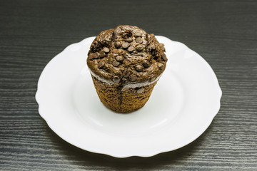 Muffin - chocolate cake on a plate.