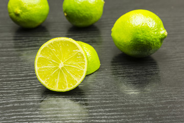 Half a lime fruit on a wooden dark table.