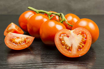 Cut in half a red tomato on a wooden table.