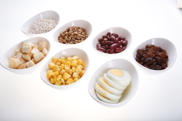 Group of  croutons, redbean, boiled eggs,sunflower seed, raisins and corn