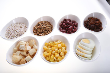 Group of  croutons, redbean, boiled eggs,sunflower seed, raisins and corn
