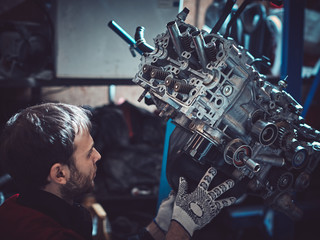 The young auto mechanic dismantles the opposing engine.