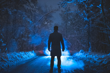 The man stand near the smoke in the winter forest. evening night time - Powered by Adobe