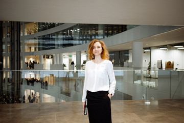 Business portrait. The business woman in a white blouse and a black skirt