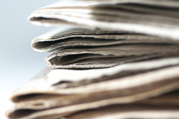 A bunch of folded newspaper close up shot isolated on white background.