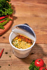 instant noodle, asian fast food, noodle cup on wooden background.
