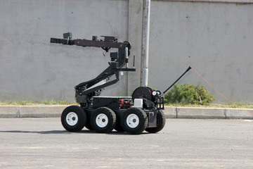 Terrorism. Bomb. Robot. A robot disarm a bomb inside a car of terrorists. Bomb squad robot. 
