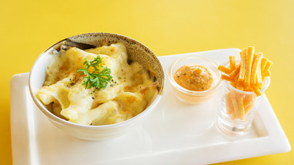 french fries with cheese on a yellow table.