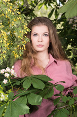  Like jungle.Vertical portrait of a beautiful young woman with her natural hair in a flowered garden