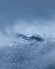 Dramatic winter mountain scenery at Slovakia, Mala Fatra, Klak. Snow storm closing in on frozen forests and hiding Klak peak to cold winter mist.