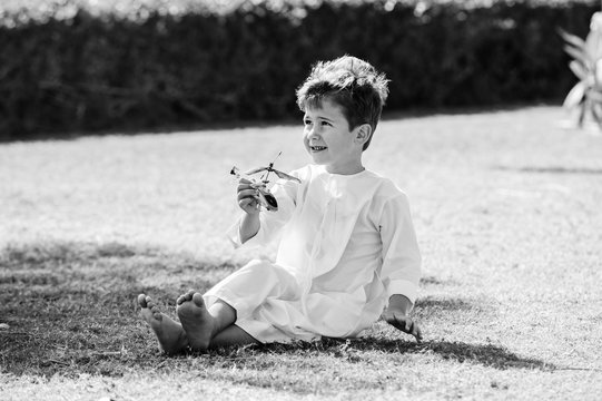 Arabic boy plays with toy helicopter.Black and white.