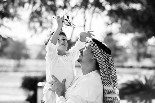 Arabic father and little kid play outdoors.Black and white.